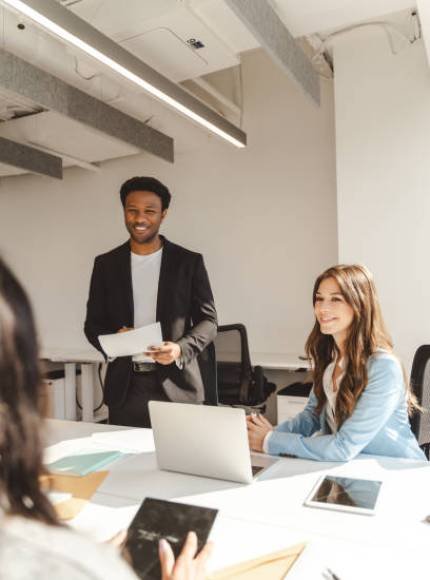 istockphoto-2182810947-612×612 Young businessman holding documents and leading a team meeting in a modern office